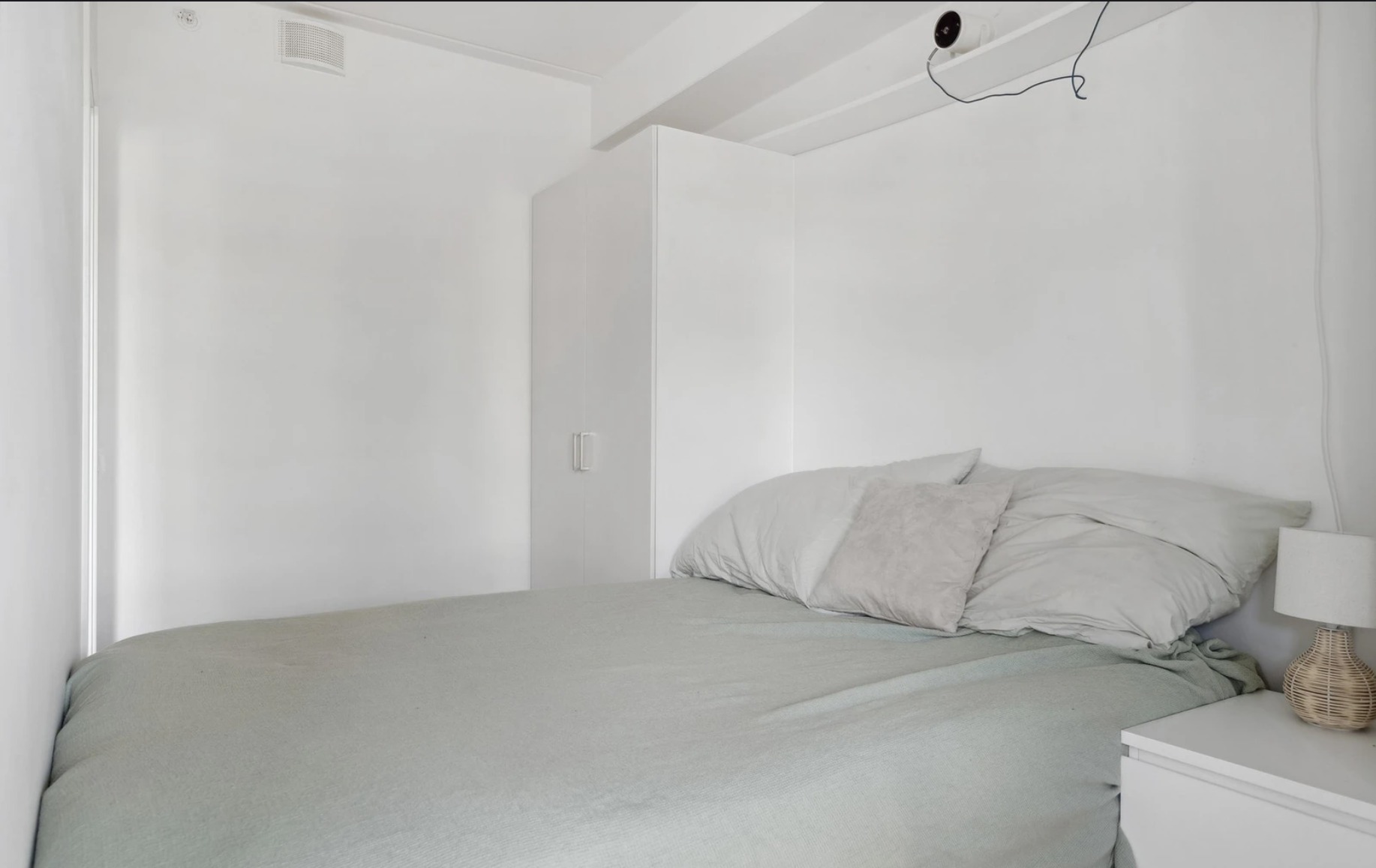 Garderobeskap ligger på hver side av sengen.